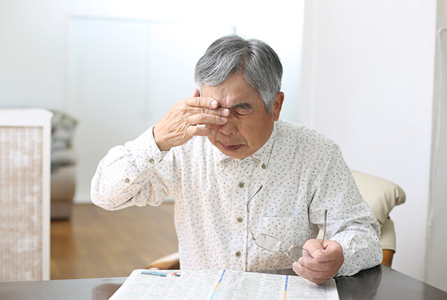 目を押さえている高齢の男性